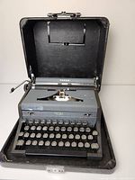 Front view of Royal Arrow typewriter inside carrying case, showing keyboard and case interior