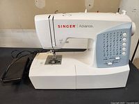 Full front view of white Singer Advance sewing machine on table