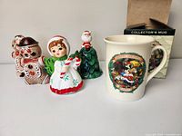 Lot of vintage Christmas ceramics and Disney mug arranged on flat surface showing all items.