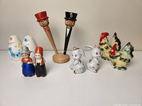 All salt and pepper shakers displayed together on table, showing variety of styles and designs including animals, figures, and whimsical characters.