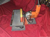 Side view of Black & Decker High Output Sander Grinder tool on base, showing working platform and sanding disc.