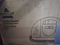Close-up photo of Bissell box showing branding and model details for Little Green Portable Deep Cleaner Model 1400B.