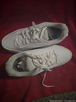 Top down view of white women's size 10.5 wide athletic shoes showing the laces and interior cushioning.