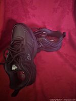 Pair of Skechers Relaxed Fit men's shoes size 6.5 on red background showing side and top views