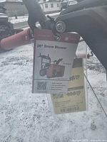 Front view of snow blower showing clearing housing, chute, and control handles