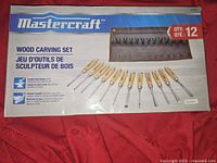 Packaging box showing 12 piece Mastercraft wood carving tool set with forged steel blades and wooden handles, including storage pouch.
