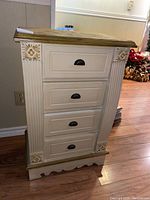 Front view of the painted wood cabinet showing the four drawers and column side details.