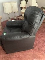 Front right-angle view of black faux leather recliner showing padded arm, seat and high back.