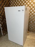 Exterior view of white upright freezer with closed door