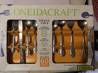 Photo of the box front showing OneidaCraft stainless steel service for 8 silverware set with 60 pieces total, including 8 five-piece place settings, 4-piece hostess set, and 8 extra teaspoons.