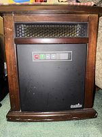 Front view of Duraflame space heater showing dark brown wooden-style exterior and black front control panel with buttons and display.
