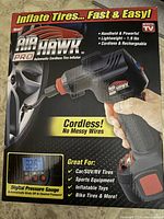Photo of the retail box showing Air Hawk Pro branding and features including cordless operation, digital pressure gauge, and suitability for multiple tire types.