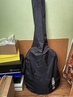 Black padded soft case labelled Yamaha covering an acoustic guitar