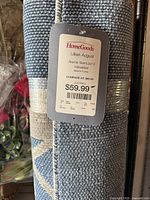 Close-up of the rug's HomeGoods branded tag showing dimensions 5.2 x 7.2 feet, new with tags, made in Turkey, price $59.99