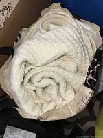 Cream waffle weave blanket rolled inside fabric bag