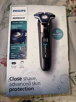 Box showing Philips Norelco Shaver 7200 with product features and front image of the shaver.