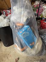 Large bag filled with multiple boxes of latex gloves and other gloves inside a clear plastic bag