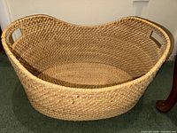 Large natural wicker basket with handles, oval shape, tightly woven pattern