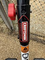 Close-up of Craftsman brand label on weed whacker shaft showing convertible model details