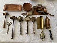 Full lot showing all the assorted brass and wooden items on a white fabric background.