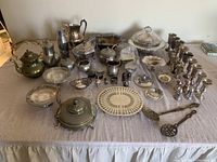 Full spread of all silver-plated serveware and decorative items on table