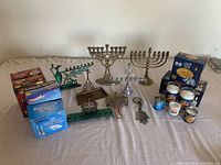 Wide shot of all menorahs, memorial candles, and boxes of disposable candle holders arranged on table