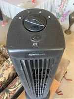 Close-up of the heater's top control panel showing a rotary dial with settings 0 to 3 and an oscillation on/off switch labeled 'OSC'. The brand 'HomeStyles' is visible below controls.