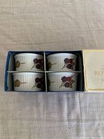 Four white porcelain ramekins with ribbed sides and blackberry spoon design, shown inside original blue box with cardboard dividers.