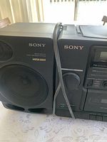 Close-up of left Sony speaker showing Mega Bass and Bass-Reflex 2-way speaker markings, and connection wire