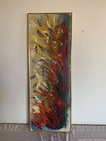 Full view of the vertical abstract painting showcasing colorful brush strokes in red, yellow, blue and white within a gold frame.