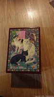 Closed wooden music box with a colorful printed lid featuring three cats surrounded by flowers.