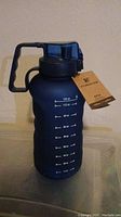 Single dark blue 1-gallon Hydro Flow water bottle with measurement markings and black handle on top, tagged as new.