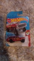 Packaged Hot Wheels '64 Nova Wagon Grasser die-cast toy car on blue and red backing card