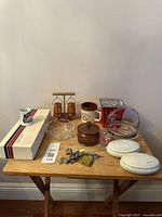 Photo showing the assorted items on a wooden table consisting of trinket boxes, salt and pepper shakers, souvenirs, locks with keys.
