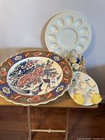 Overall view of three plates on a wooden table showing Easter egg plates and a large floral serving plate