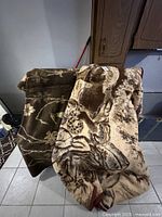 Two heavy blankets draped over a chair showing their overall design and thickness