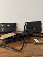 Purses grouped on wooden surface, showing various styles and materials