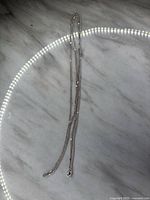 Full length view of the 30 inch sterling silver chain with a shiny polished finish and thin link thickness