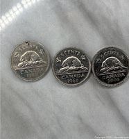 Three Canadian 5 cents coins reverse side showing a beaver on a rock dated 1994, 1968, and 2006.
