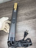 Front view of Chi clothes steamer showing steam head, power button, and power cord with plug coiled.