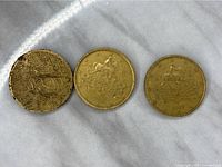 Three Italian 50 Euro cent coins displayed obverse side featuring a mounted horseman design. Coins show some wear and tarnish, one is noticeably darker and more worn than the others.