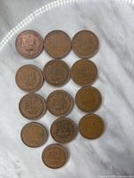 Top side of 13 Japan 10 Yen coins showing denomination and wreath design.