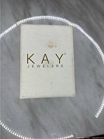 Kay Jewelers white box with gold lettering on top.