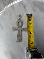Front side of a vintage 925 silver ankh cross pendant with a measuring tape showing about 2.25 inches in length.