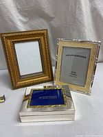 Two vintage ornate picture frames and a silver plated musical jewelry box shown from the front.
