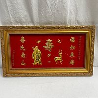 Full frontal view of the framed Chinese wall art showing the red velvet background with 24K gold foil motifs and gilded ornate frame.