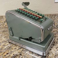 Side angled view showing the body, keys, and lever of the adding machine