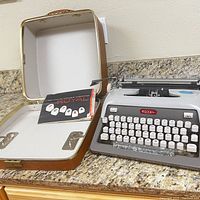 Typewriter and original carrying case open, includes Royal Futura user manual booklet inside case