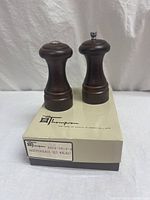 Front view of walnut wood salt and pepper shakers on original Thomson box.