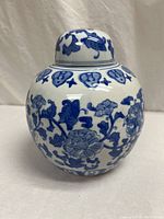 Side view of ginger jar with the removable lid placed beside it showing top opening.